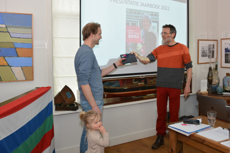 Het eerste jaarboek 2022 wordt door Nathan Brinkman aangeboden aan Maarten de Groot, kleinzoon van Joke Folmer (foto Romy Dam)