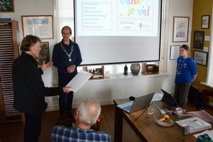Arend Maris biedt het eerste jaarboek aan (foto Romy Dam)