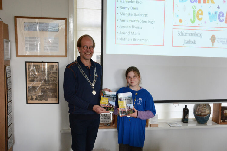 (Foto Romy Dam) Het eerste jaarboek 2025 werd aangeboden aan burgemeester Hendri Meendering en kinderburgemeester Benthe Hagen